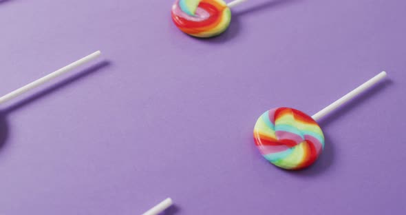 Video of rows multicoloured lollipops on blue background alt