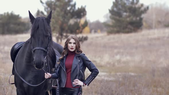 Beautiful Young Woman Stroking a Horse and Posing Outdoors alt