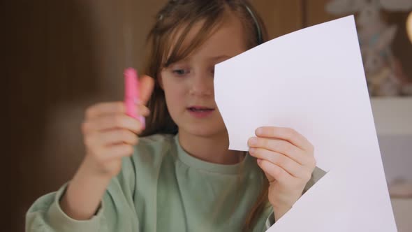 Girl Cuts Paper With Scissors alt