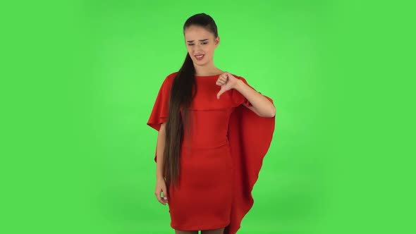 Pretty Young Unhappy Woman Is Showing Thumbs Down Gesture. Green Screen alt