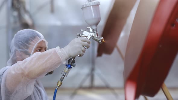 Master is Painting Part of Automobile in Car Service Modern Car Painting alt