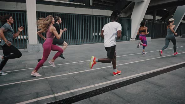 Side View of Enduring and Attractive Athletes of Different Genders and Races Running a Marathon alt