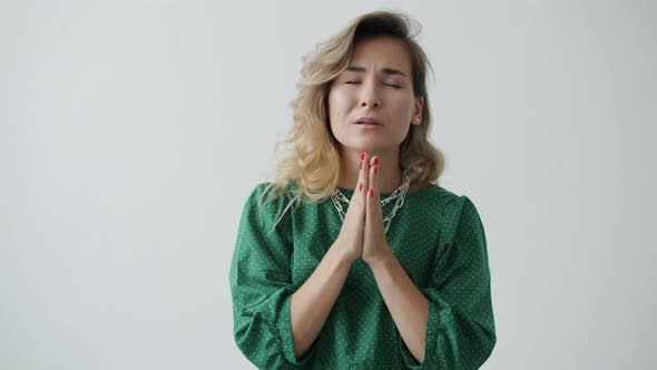 Portrait of Helpless Girl Asking for Help Making Prayer Hand Gesture and Looking at Camera alt