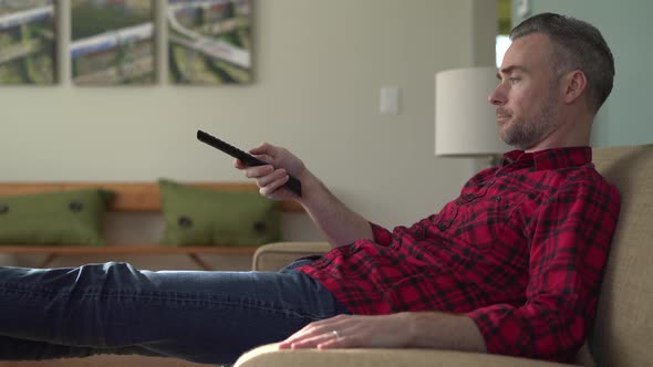 Man Laying on Couch Channel Surfing alt