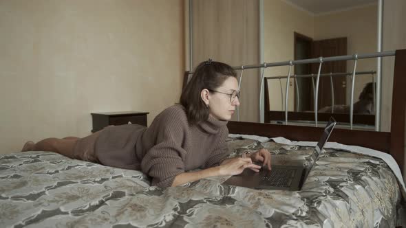 Woman Wearing Sweater Works on Notebook
