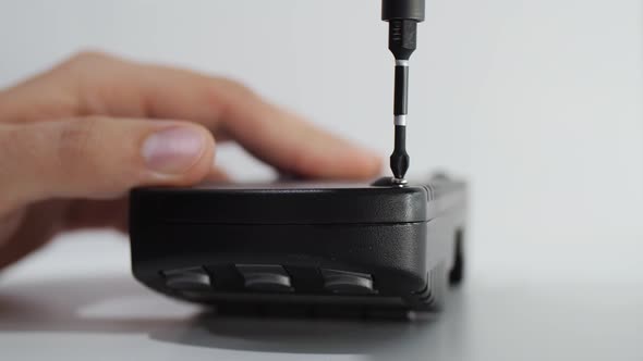 Unscrewing Small Screw with Screwdriver To Repair Battery Charging alt