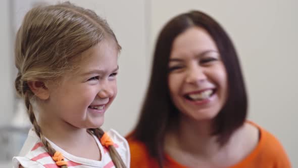 Side View of Laughing Mother and Daughter alt