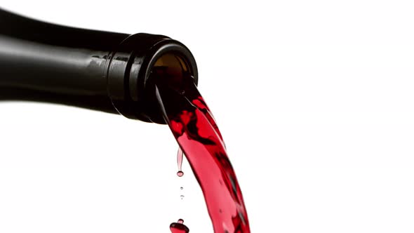 Super Slow Motion Detail Shot of Pouring Red Wine From Bottle Isolated on White at 1000Fps. alt
