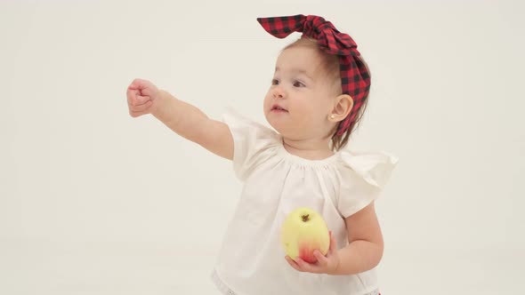 Little Girl in Plaid Headband is Holding Apple alt