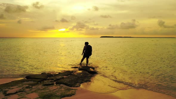 Beautiful happy lady on vacation in the sun on the beach on sunny blue and white sand 4K background alt