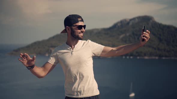 Selfie On Mobile Phone In Beautiful Place In Sea Vacation. Man Taking Self Photo And Answer Video. alt