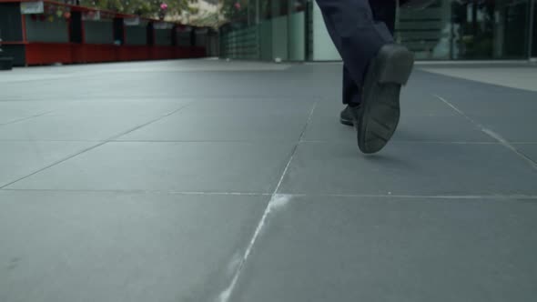 A Man Businessman in an Expensive Suit with a Briefcase in His Hand Walks Along the City Street at alt