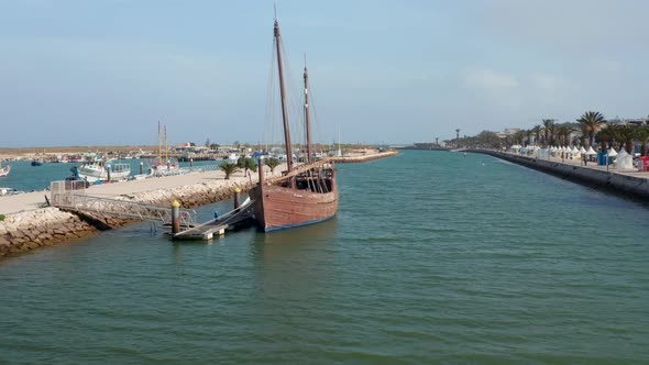 Lagos Harbor Canal with Wooden Boat Portuguese Caravela Anchored on Dock alt