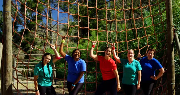 Portrait of female trainer and women standing near net alt