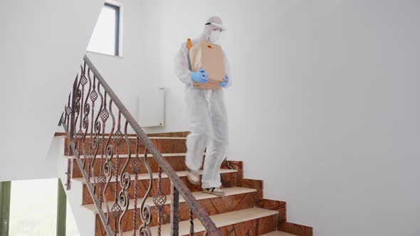 Volunteer in Hazmat Suit Delivering Charity Food alt