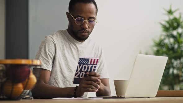 Handheld video of focused black man holding vote leaflet. Shot with RED helium camera in 8K. alt