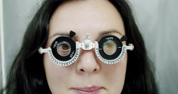 Close Up Eyesight Measurement To Young Woman with Optical Phoropter. Woman Doing Eye Test Slow alt