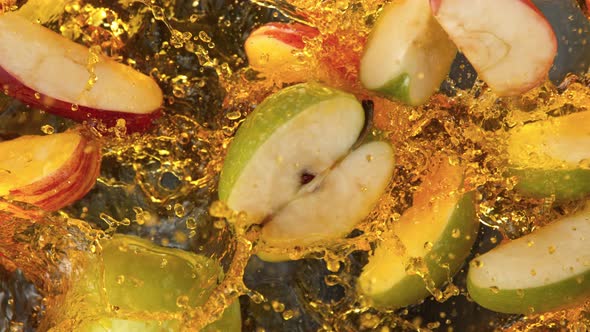 Super Slow Motion Shot of Red and Green Apple Cuts Falling and Splashing Into Juice at 1000Fps alt