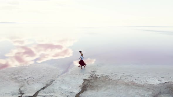 Romantic Couple Hugging and Kissing on Salty Shore of Pink Lake alt