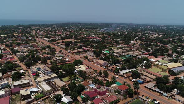 Aerial flight towards an unnamed road in Serrekunda above the Manjai football field alt