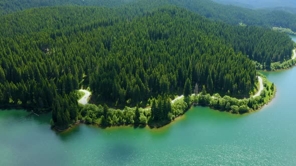 Aerial view over beautiful mountain road with turquoise lake and green forest. Baikal Lake Siberia alt