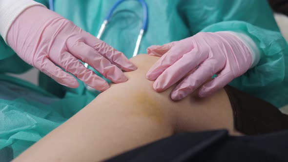 The Doctor Feels the Patient's Knee Damaged As a Result of an Injury alt