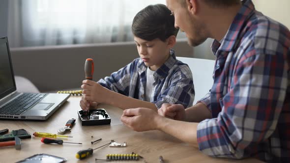 Caring Father Teaching His Little Son to Repair Hard Disk Drive at Home, Hobby alt