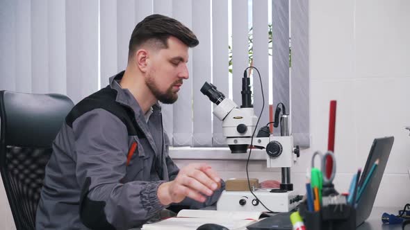 Man Working with a Microscope in a Lab