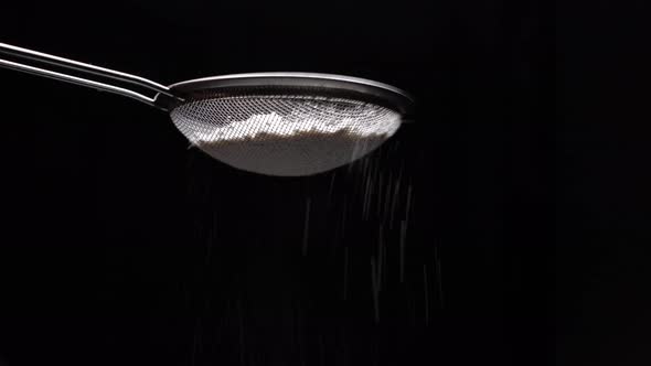 Chef Sifting Flour Through A Sieve For Making Dessert, Black Background