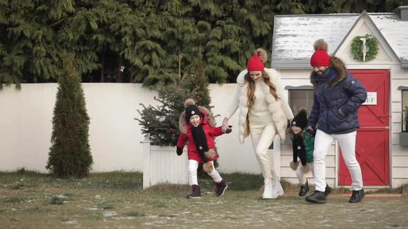 Xmas Family Holidays Young Parents Kids Holding Hands Running Joyfully Outdoor Near Christmas Tree