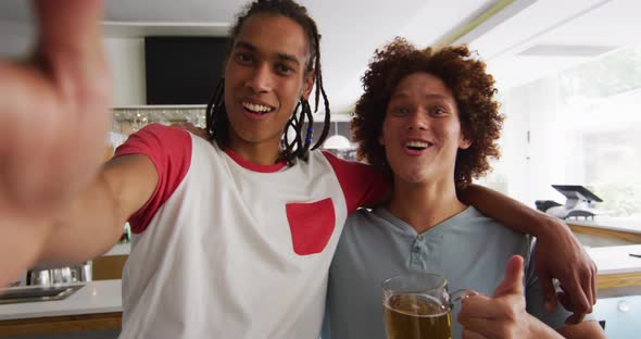 Diverse group of happy friends watching a game drinking beers and taking a selfie at a bar alt