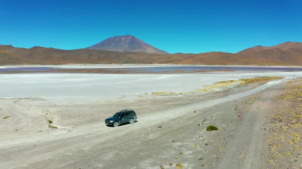 The Car Drives Through the Desert Landscape of Altiplano Bolivia alt