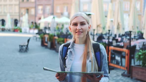 Zoom Shot of Trendy Young Woman with Map Smiling To the Camera alt