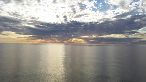 AERIAL: Flying Backwards Above Baltic Sea During Golden Hour with Majestic Horizon alt