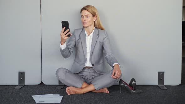 Businesswoman Making a Video Call Sitting on the Floor Online Meeting with Team alt
