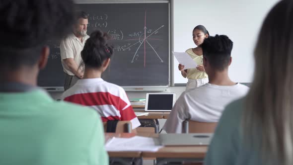 Latin Female High School Student Presenting a Project or Reading a Composition to Classmates and alt