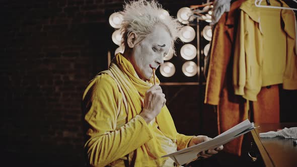 Mime with Makeup Crosses Out Lines in Script with Pencil alt