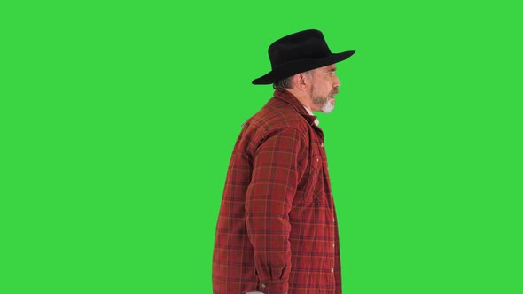 Elderly Caucasian Cowboy in a Hat Walking on a Green Screen Chroma Key alt