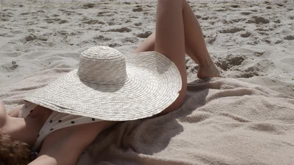Brimmed Hat Covering Tanned Body of Gorgeous Woman Lying Sand Beach Close Up alt