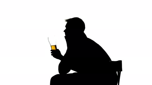 Man Drinks Beer From a Glass. Side View. Silhouette White Background alt
