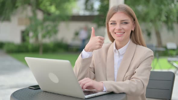 Thumbs Up By Young Businesswoman with Laptop in Outdoor Cafe alt