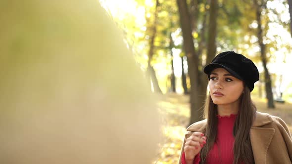Thoughtful Girl in Stylish Clothes Posing and Looking Around in Autumn Park alt