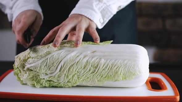 The Chef Is Cutting a Cauliflower on a Cutting Board alt