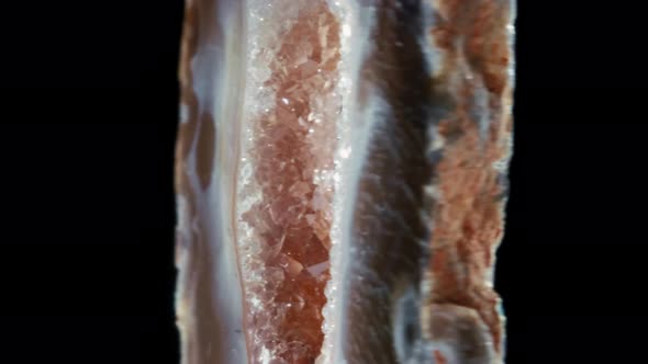 Agate with Quartz. Agate Rotates Around Its Axis on a Black Background. alt