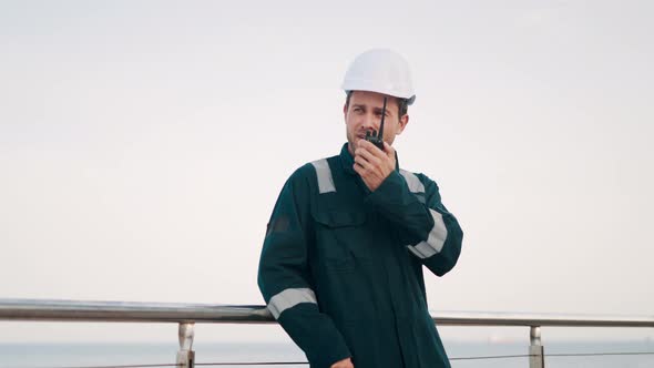 Port Worker Talking on Walkietalkie Radio While Doing Cargo Logistics Control in Seaport alt