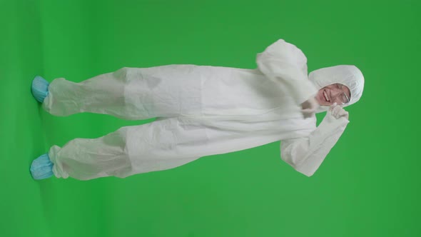 Full Body Of Asian Male Wearing Protective Uniform Ppe And Dancing In Green Screen Studio alt