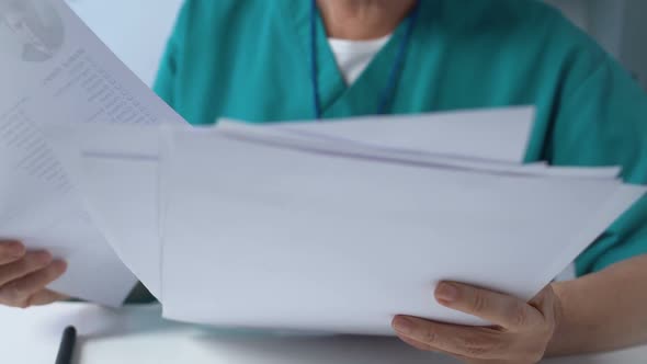 Senior Female Doctor Signing Medical Documents, Pharmacological Research