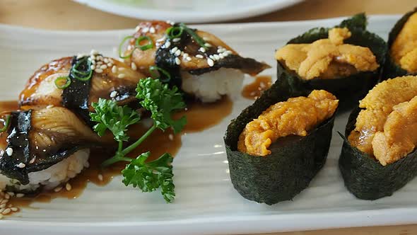 Japanese food, Sushi set (eel sushi, sea urchin sushi, squid sushi ) on white plate. paning right.