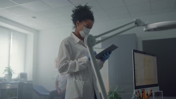 Woman Therapist Looking Patient Data on Tablet alt