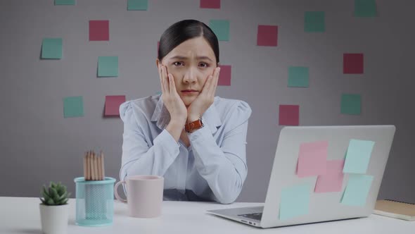 Asian woman sadness and bored working on a laptop at home office